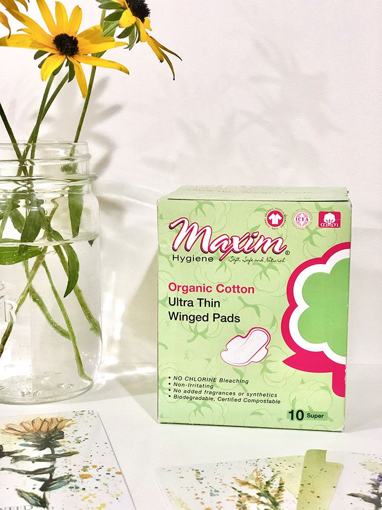Maxim Hygiene organic cotton ultra thin winged pads (10 super) in green box packaging, featuring chlorine-free, non-irritating protection with no added fragrances or synthetics, biodegradable and certified compostable.