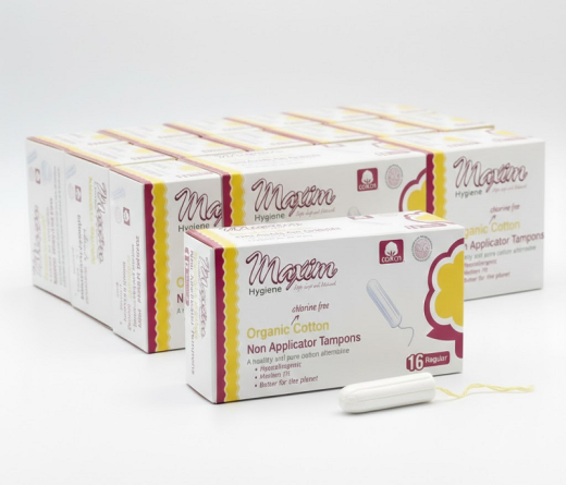 A sealed case containing 12 packs of Maxim® 100% Certified Organic Cotton Non-Applicator Tampons in Super Plus absorbency, totaling 192 individual tampons. The packaging prominently features the brand, product type, and key certifications.