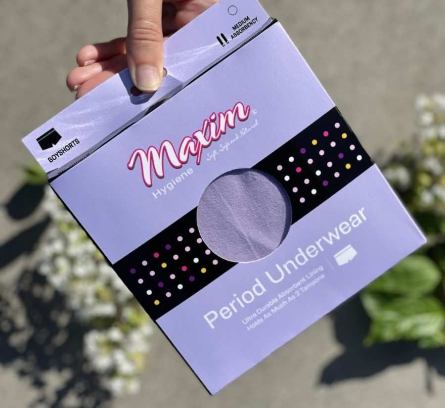 Hand holding Maxim period underwear boyshorts package in lavender with medium absorbency, reusable leak-proof menstrual underwear.